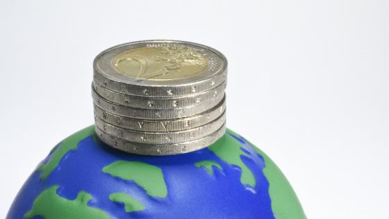 在地球仪上堆叠的欧元硬币的图像