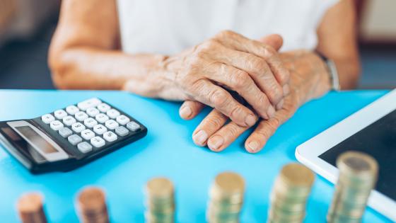 老女人与计算器和成堆的硬币