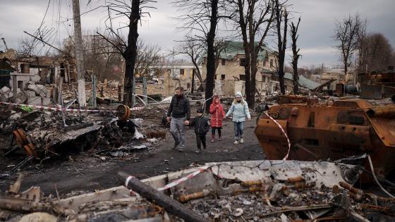 在基辅郊区的Bucha，一个家庭走在被摧毁的俄罗斯坦克中间