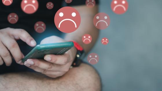 人使用手机环绕悲伤面部emojis