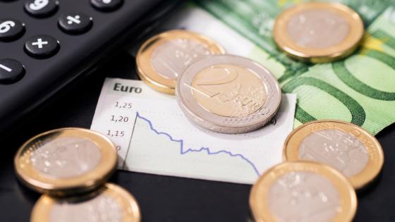 欧元硬币、纸币和显示货币疲软的图表