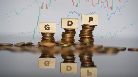 GDP写在木积木在成堆的硬币前面的图